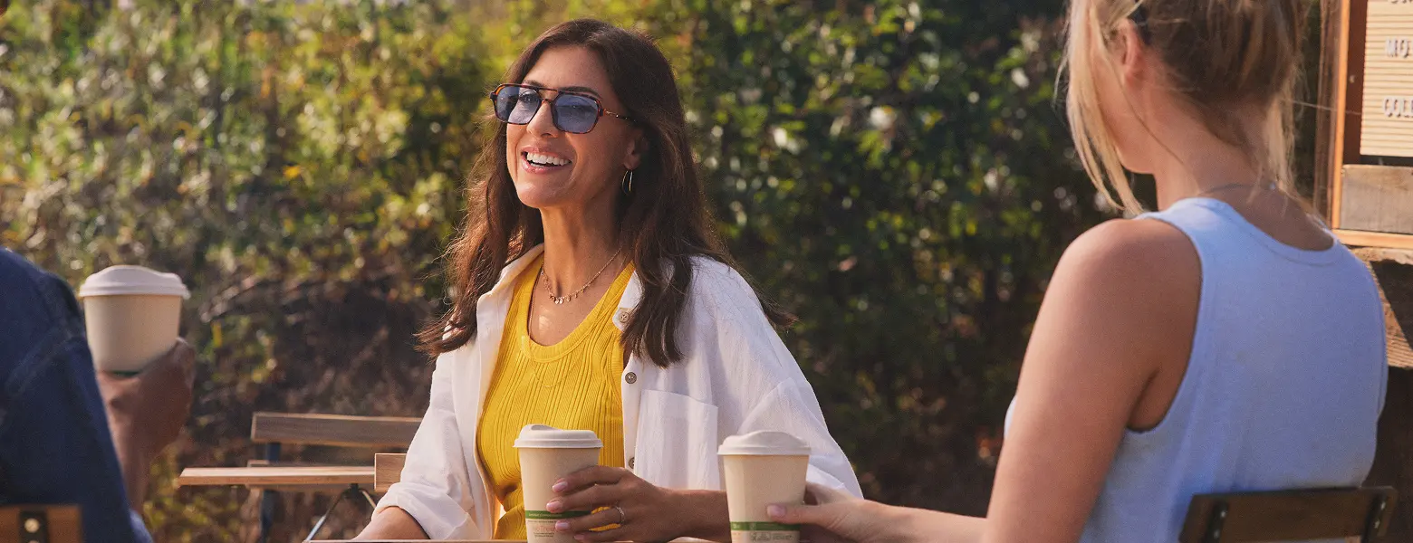 Hypothetical EKTERLY® (sebetralstat) patient sitting outside with a drink