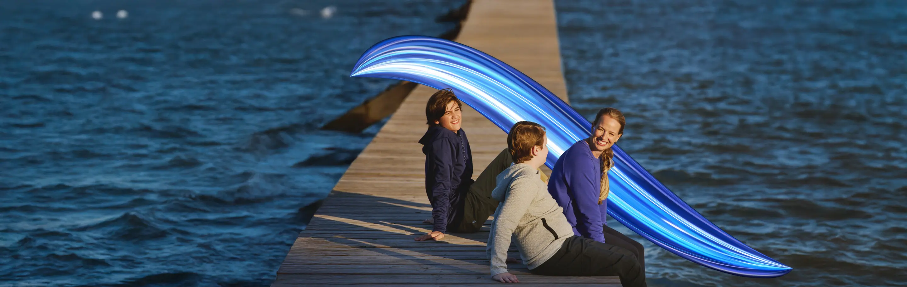 Real EKTERLY® (sebetralstat) patient Cari sitting on a dock with children laughing